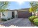 Charming single-story home showcasing a well-manicured lawn and a two-car garage, complete with stone accents and desert landscaping at 5633 Alitak Bay St, North Las Vegas, NV 89081