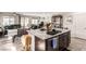Spacious kitchen features a center island with a sink, stainless appliances, and dark wood cabinets at 5633 Alitak Bay St, North Las Vegas, NV 89081