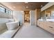 Stunning bathroom featuring a soaking tub, walk-in shower, and a dual sink vanity with wood accents at 5741 S Pearl St, Las Vegas, NV 89120