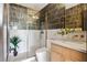 Modern bathroom with sleek, vertical tiling, glass-enclosed shower, and a floating vanity at 5741 S Pearl St, Las Vegas, NV 89120