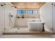 Modern bathroom features a freestanding tub, dual shower heads, and black trim windows at 5741 S Pearl St, Las Vegas, NV 89120