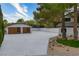 Wide driveway leading to a detached garage with wood doors and desert-style landscaping at 5741 S Pearl St, Las Vegas, NV 89120