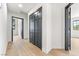 Hallway with wood-look flooring and dark-trimmed doors and closet at 5741 S Pearl St, Las Vegas, NV 89120