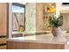 Kitchen featuring a stone wall, farmhouse sink, and a gold faucet under a large window at 5741 S Pearl St, Las Vegas, NV 89120