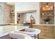 Custom kitchen with island seating, stainless steel appliances, and decorative stone accents on adjacent walls at 5741 S Pearl St, Las Vegas, NV 89120