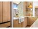 Kitchen featuring a stone wall, a farmhouse sink under a window, and wooden cabinets at 5741 S Pearl St, Las Vegas, NV 89120