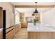 Bright kitchen features custom wood cabinets, large island with seating, and stone accents around shelving at 5741 S Pearl St, Las Vegas, NV 89120
