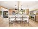 Bright kitchen with island, modern light fixtures, bar stool seating, and stainless steel appliances at 5741 S Pearl St, Las Vegas, NV 89120