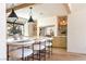 Bright kitchen features a quartz island, modern lighting fixtures, stone accents, and wood beams at 5741 S Pearl St, Las Vegas, NV 89120