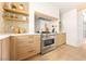 Modern kitchen featuring stainless steel appliances, wooden cabinets, stone walls, and open shelving at 5741 S Pearl St, Las Vegas, NV 89120