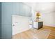 Stylish laundry room with light blue cabinetry, wood floors, open shelves, and a sink at 5741 S Pearl St, Las Vegas, NV 89120