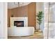 Bright living room featuring a fireplace, wood slat accent wall, modern lighting, and decorative tree at 5741 S Pearl St, Las Vegas, NV 89120