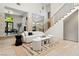 Well-lit living room with a fireplace, modern staircase, and large windows overlooking the backyard at 5741 S Pearl St, Las Vegas, NV 89120