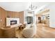 Open-concept living room with fireplace, accent wall, modern chandelier, and access to the kitchen area at 5741 S Pearl St, Las Vegas, NV 89120