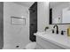 Modern bathroom with white and black tiled walls, a sleek vanity, and a walk-in shower at 5800 Balzar Ave, Las Vegas, NV 89108