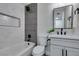 Stylish bathroom featuring a combined tub and shower with gray accent tiles, a modern vanity, and a sleek black mirror at 5800 Balzar Ave, Las Vegas, NV 89108