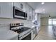 Modern kitchen with white cabinets, countertops, stainless steel appliances, and wood flooring at 5800 Balzar Ave, Las Vegas, NV 89108