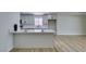 Bright and spacious kitchen featuring white cabinets, countertops, an island, and wood flooring at 5800 Balzar Ave, Las Vegas, NV 89108