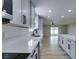Modern kitchen featuring white cabinets, countertops, stainless steel appliances, and wood flooring at 5800 Balzar Ave, Las Vegas, NV 89108