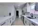 Modern kitchen featuring white cabinets, countertops, stainless steel appliances, and wood flooring at 5800 Balzar Ave, Las Vegas, NV 89108
