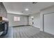 Bright living room features a brick fireplace, gray carpet, and a view into the kitchen at 5800 Balzar Ave, Las Vegas, NV 89108