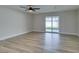 Inviting living room featuring wood-look floors and a sliding glass door to the yard at 5800 Balzar Ave, Las Vegas, NV 89108