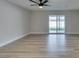 Bright living room featuring wood-look flooring, ceiling fan, and sliding glass door to the backyard at 5800 Balzar Ave, Las Vegas, NV 89108