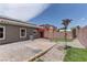 View of the backyard with gravel, synthetic grass, red patio canopy, and block wall at 6236 Tierra Cove St, North Las Vegas, NV 89081