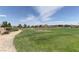 Expansive green community park featuring walking path, lush landscaping, and mature trees at 6236 Tierra Cove St, North Las Vegas, NV 89081