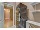 Laundry area featuring a modern stacked washer and dryer, with shelving and wood flooring at 6236 Tierra Cove St, North Las Vegas, NV 89081