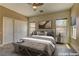 Serene main bedroom with a ceiling fan, neutral decor, and two windows for natural light at 6236 Tierra Cove St, North Las Vegas, NV 89081