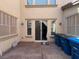 View of the back patio with sliding glass doors and garbage bins outside at 6554 Macdoogle St, Las Vegas, NV 89166