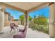 Inviting covered balcony with charming seating area and views of lush greenery at 6554 Macdoogle St, Las Vegas, NV 89166