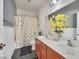 Well-lit bathroom features a dual sink vanity, framed mirror and shower with curtain at 6554 Macdoogle St, Las Vegas, NV 89166