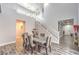 Elegant dining room with vaulted ceilings, stylish seating for six, and modern decor with a staircase at 6554 Macdoogle St, Las Vegas, NV 89166