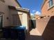 Exterior view of the backyard and side yard, showing a walkway, wall, and bins at 6554 Macdoogle St, Las Vegas, NV 89166
