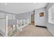 Upstairs hallway features neutral carpet, crisp white railings and plenty of natural light at 6554 Macdoogle St, Las Vegas, NV 89166