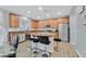 Modern kitchen featuring an island with bar seating, stainless steel appliances, and wood cabinets at 6554 Macdoogle St, Las Vegas, NV 89166