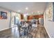 Open kitchen and dining area featuring stainless steel appliances, wooden cabinets and modern dining table at 6554 Macdoogle St, Las Vegas, NV 89166