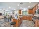 Open kitchen and dining area featuring stainless steel appliances, wooden cabinets and modern dining table at 6554 Macdoogle St, Las Vegas, NV 89166