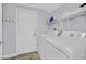 Bright laundry room with modern appliances, overhead storage, and convenient access to the outdoors at 6554 Macdoogle St, Las Vegas, NV 89166
