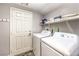 Functional laundry room with washer, dryer, storage shelves and access door at 6554 Macdoogle St, Las Vegas, NV 89166