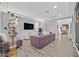 Spacious living room with a comfortable purple sofa, large TV, and modern decor at 6554 Macdoogle St, Las Vegas, NV 89166