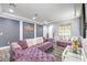 Stylish living room with modern gray walls, gray wood floors and plush purple velvet sofa at 6554 Macdoogle St, Las Vegas, NV 89166