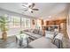 Bright living room featuring a modern gray sectional sofa, gray wood floors and adjacent to a kitchen with wood cabinets at 6554 Macdoogle St, Las Vegas, NV 89166