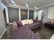 Cozy living room with large purple sectional sofa, recessed lighting and modern accents at 6554 Macdoogle St, Las Vegas, NV 89166