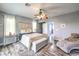 Relaxing main bedroom featuring a plush bed, modern fan, and a chaise lounge at 6554 Macdoogle St, Las Vegas, NV 89166