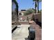 A backyard with a brick wall, a patio with chairs and decorative pieces, and a motorhome parked alongside the driveway at 6596 Secluded Ave, Las Vegas, NV 89110