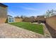 Fully fenced backyard with artificial turf and a beautiful paved patio area with seating at 6626 Evander St, North Las Vegas, NV 89086