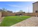 Fully fenced backyard with artificial turf and a beautiful paved patio area with seating at 6626 Evander St, North Las Vegas, NV 89086
